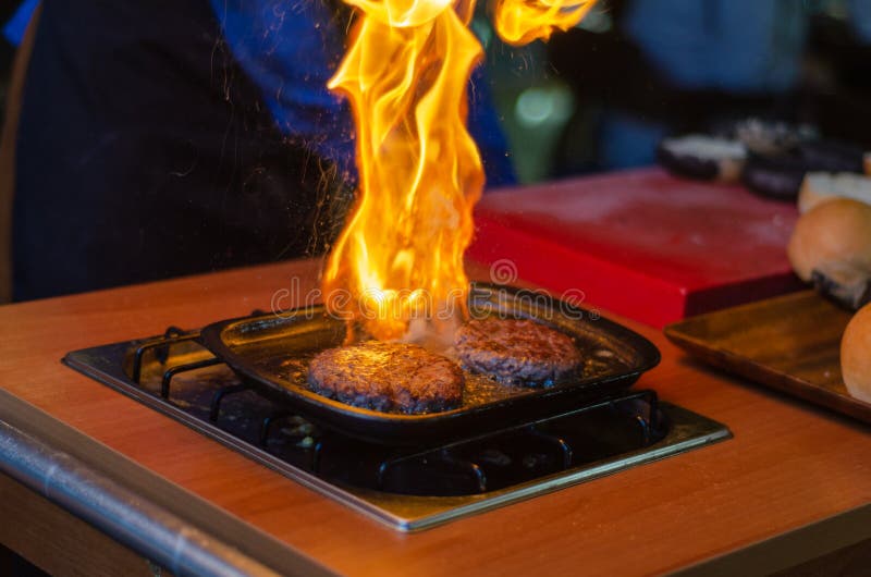 https://thumbs.dreamstime.com/b/chef-making-beef-burger-cheese-outdoor-open-kitchen-fas-cooking-flame-frying-pan-stove-128412484.jpg