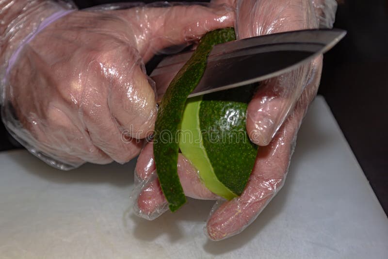 Chef is peeling avocado with sharp japanese knife. Traditional big metal pot stock images, royalty-free photos and pictures