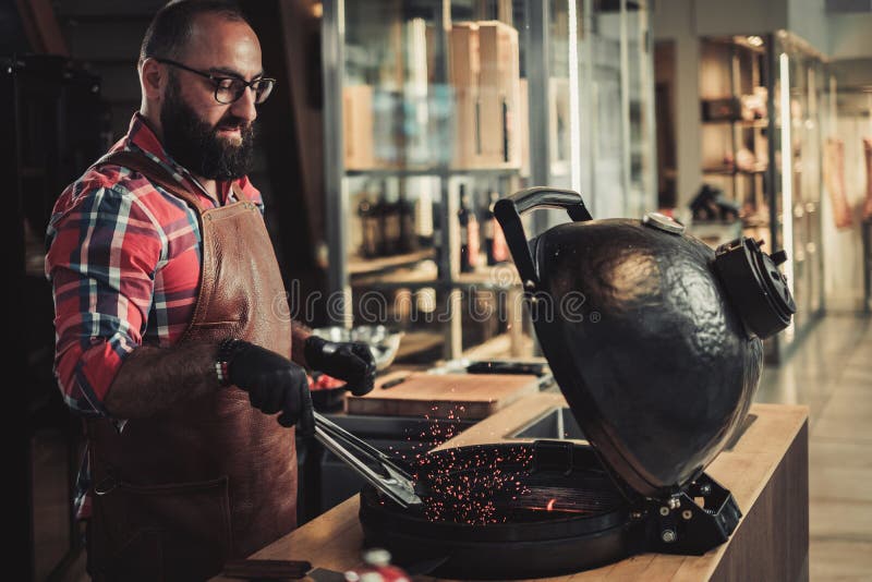 Chef Preparing Charcoals before Grilling in a Restaurant Stock Photo