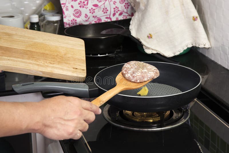 Chef putting beef Burger cooking in the pan stock photos