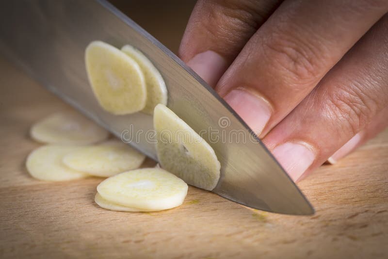Chef slicing garlic cloves stock image. Image of knife 44168265