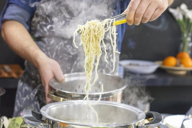 Chef Takes Out With Slotted Spoon Hot Steaming Egg Noodles From The Pan