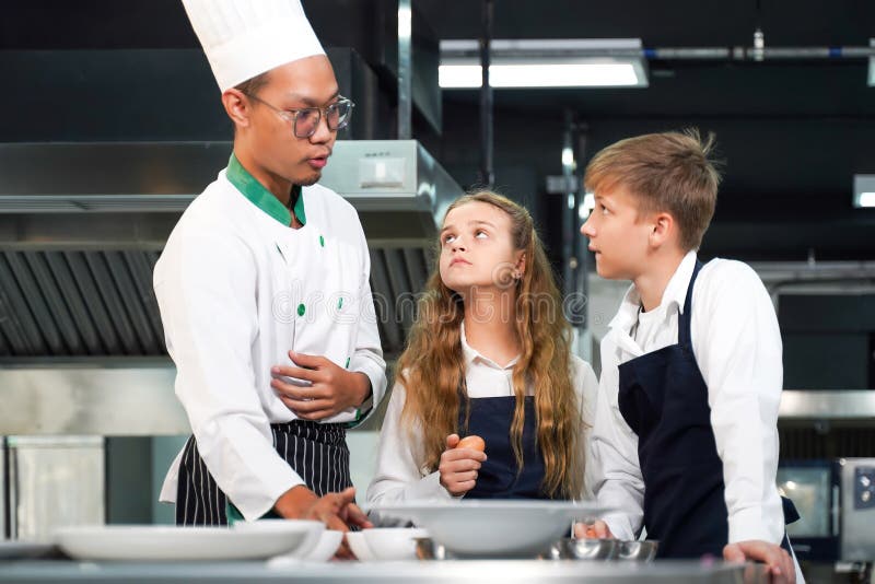 Chef Teacher Teaches Cooking To the Group Children in Class Kitchen