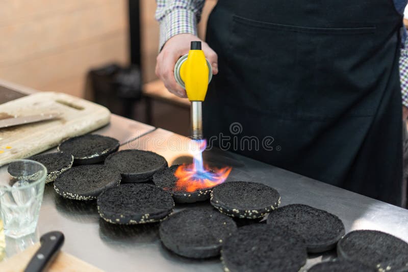 Chef Using a Culinary Torch To Make Buns Crispy Stock Photo - Image of