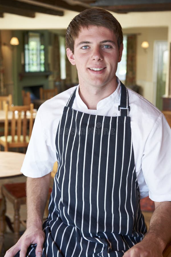 Chef-Wearing Whites And-Schutzblech, das im Restaurant sitzt stockfoto Chef-Wearing Whites And-Schutzblech, das im Restaurant sitzt stockfoto