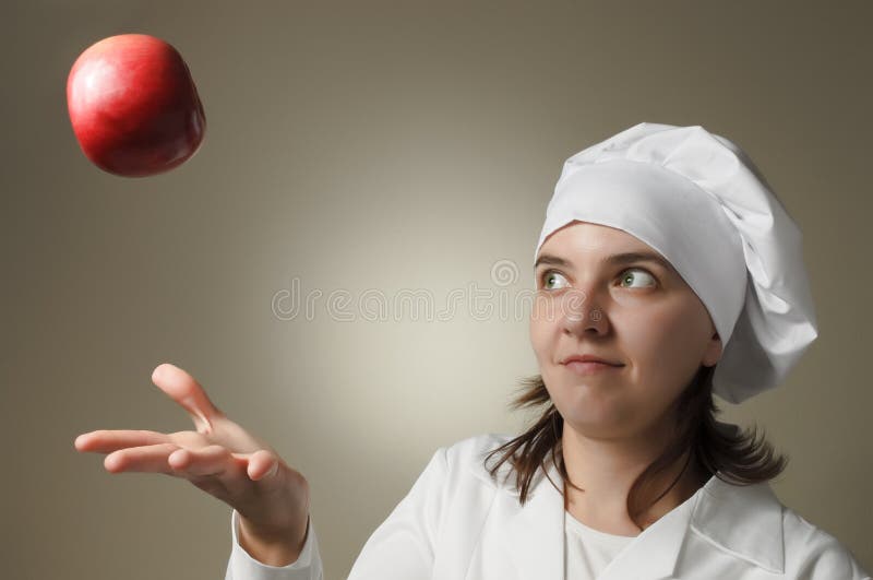 Chef woman throwing an apple