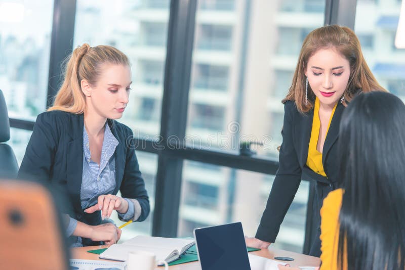 Chefe da diretora, ajudando e ensinando seu oficial no escritório, Equipe de empresárias está brainstorming com colega de equipe fotografia de stock Chefe da diretora, ajudando e ensinando seu oficial no escritório, Equipe de empresárias está brainstorming com colega de equipe fotografia de stock