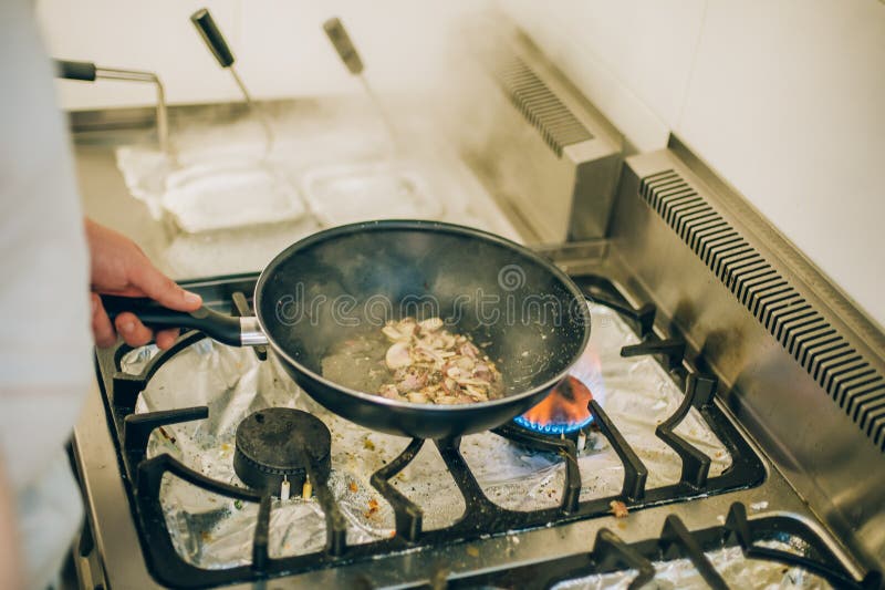 Chefkoch bereitet Mahlzeit auf Bratpfanne in der Küche vor stockfotos Chefkoch bereitet Mahlzeit auf Bratpfanne in der Küche vor stockfotos