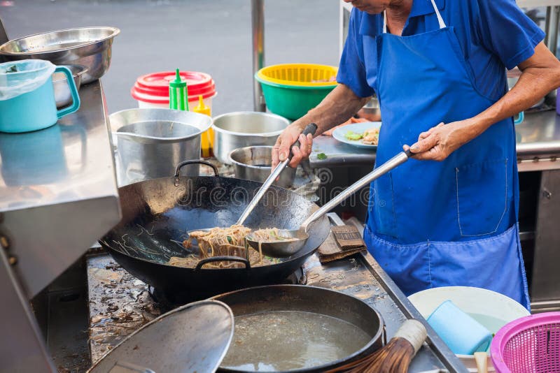 Chefköche brieten Nudeln an lizenzfreies stockbild Chefköche brieten Nudeln an lizenzfreies stockbild