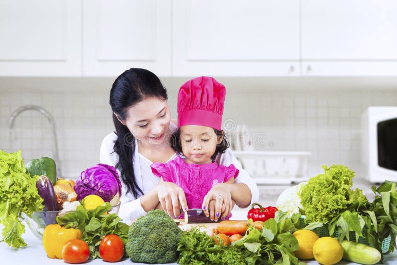 Chefmädchen lernen zu schneiden lizenzfreies stockbild Chefmädchen lernen zu schneiden lizenzfreies stockbild