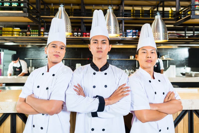 Chefs asiatiques faisant cuire dans le restaurant images libres de droits Chefs asiatiques faisant cuire dans le restaurant images libres de droits
