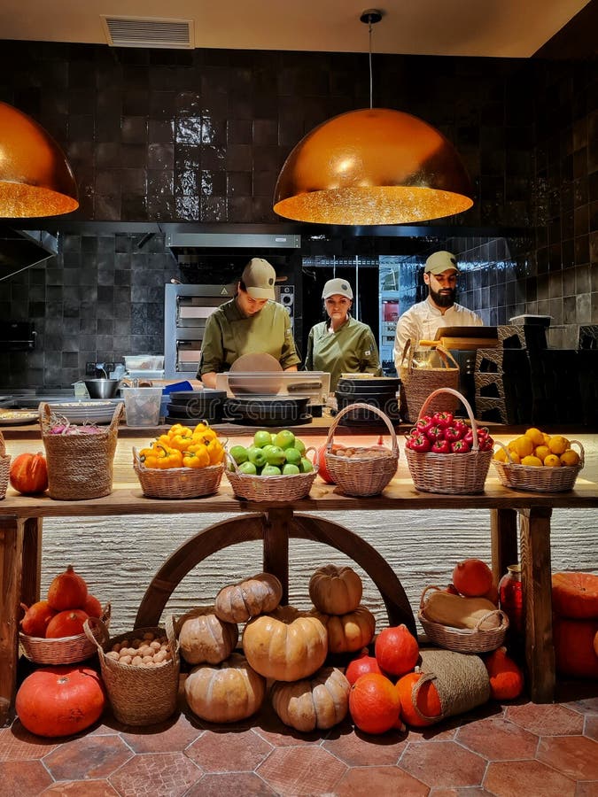 Chefs in the Kitchen in the Restaurant at the Counter and Vegetables