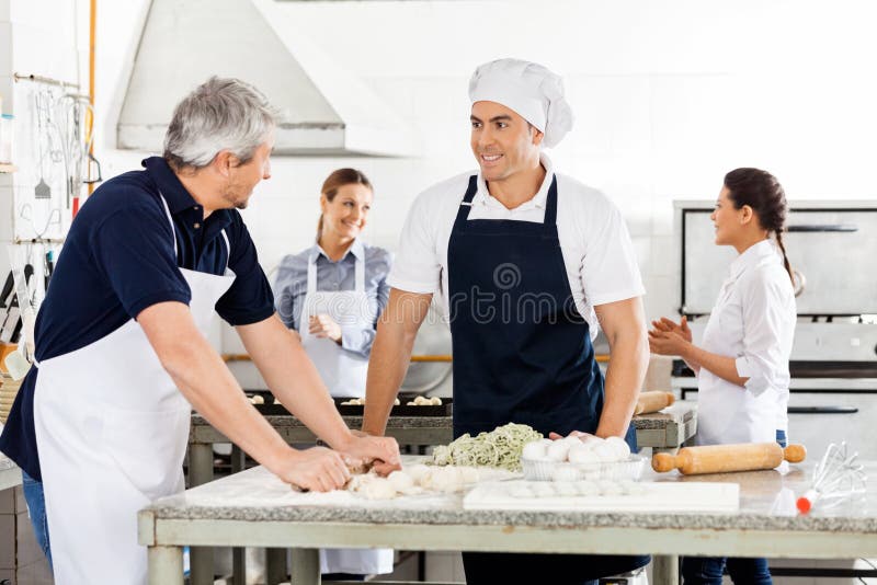 Chefs Talking While Preparing Pasta At Commercial royalty free stock photos Chefs Talking While Preparing Pasta At Commercial royalty free stock photos
