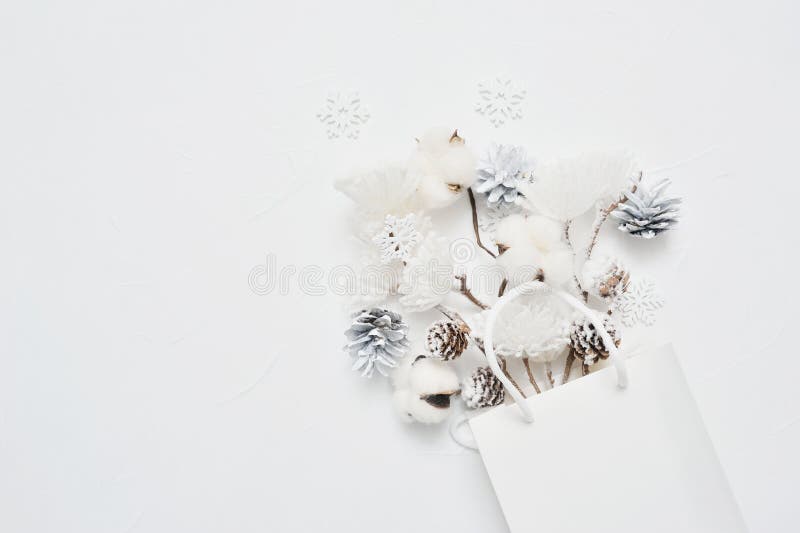 Cheiro de Natal de bouquet seco de flores de algodão, cones e flocos de neve em embalagens brancas com lugar para o seu texto