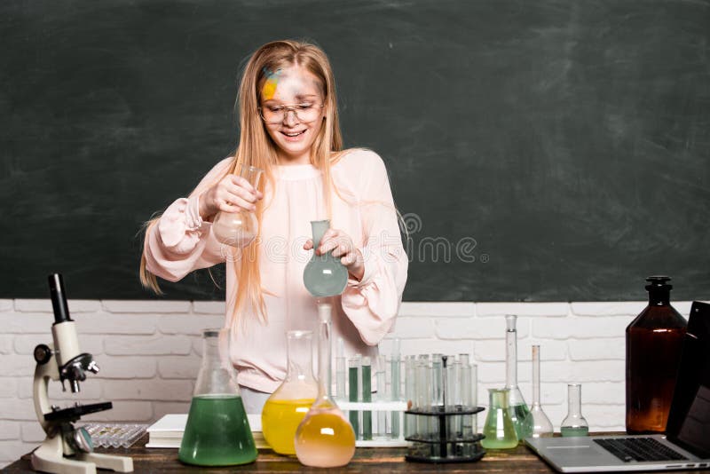 Chemical experiment. Funny schoolgirl kid doing experiments in the laboratory. Explosion in the lab. Science and education. Little girl chemical scientist in the laboratory
