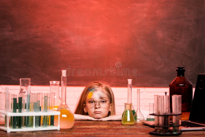 Chemical experiment. Funny schoolgirl kid with test tubes in school classroom doing experiments. Explosion in the lab. Science and education. Little girl scientist in the laboratory