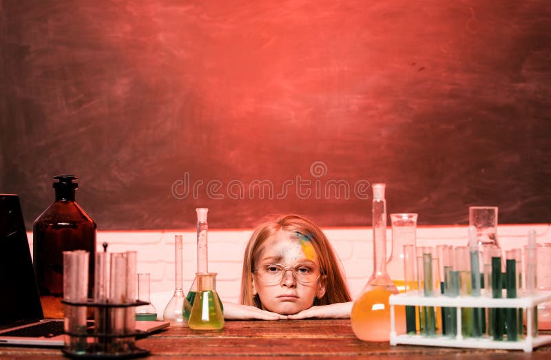 Chemical experiment. Funny schoolgirl kid with test tubes in school classroom doing experiments. Explosion in the lab. Science and education. Little girl scientist in the laboratory