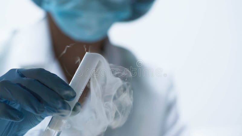 Chemical experiment, researcher holding test tube with boiling fuming liquid