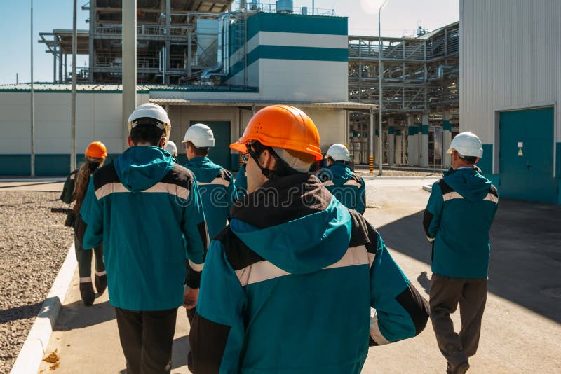 Chemical factory workers in working clothes walks to their workplaces