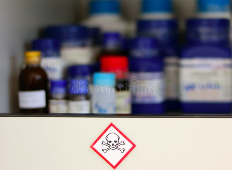 Chemical Hazard Sign pictogram, Globally Harmonized System of Classification and Labelling of Chemicals GHS Toxic category with container bottle on shelf cabinet, selective focus blurred background. Chemical Hazard Sign pictogram, Globally Harmonized System of Classification and Labelling of Chemicals GHS Toxic category with container bottle on shelf cabinet, selective focus blurred background.