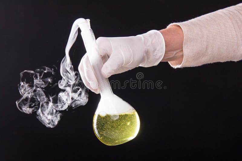 Chemical reaction in volumetric flask glass kept in the hands of