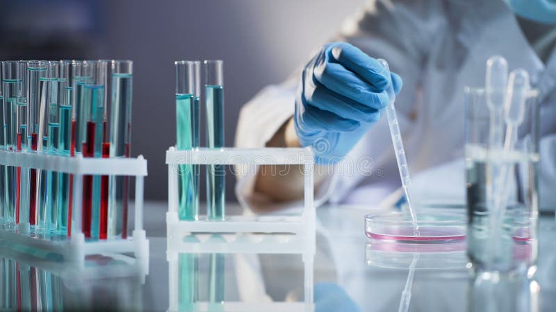 Chemicusintern die vloeistoffen mengen, die op chemische reactie bij wetenschapslaboratorium wachten stock fotografie Chemicusintern die vloeistoffen mengen, die op chemische reactie bij wetenschapslaboratorium wachten stock fotografie