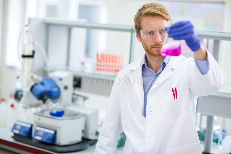 Chemie-Techniker, der flüssiges Reagens überprüft lizenzfreie stockfotos Chemie-Techniker, der flüssiges Reagens überprüft lizenzfreie stockfotos