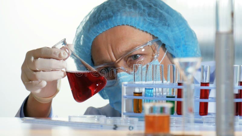 Chemielaboratorium - Onderzoeker die een vloeistof in een fles analyseren