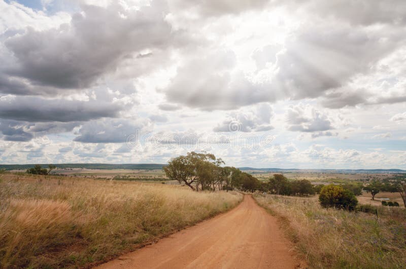 Chemin de terre de campagne parmi des champs avec le soleil par des nuages images libres de droits Chemin de terre de campagne parmi des champs avec le soleil par des nuages images libres de droits