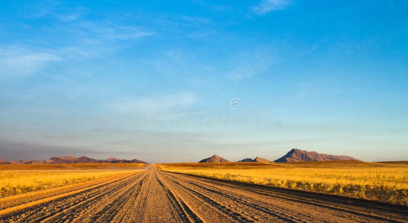 Chemin de terre vide à travers le le désert namibien photo stock Chemin de terre vide à travers le le désert namibien photo stock