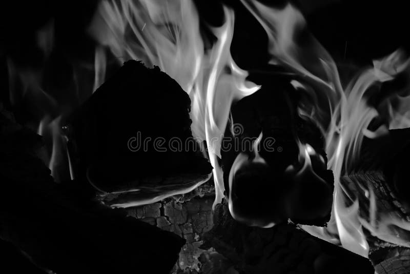 Cheminée avec bois brûlé et fourches de flamme. noir et blanc photographie stock libre de droits