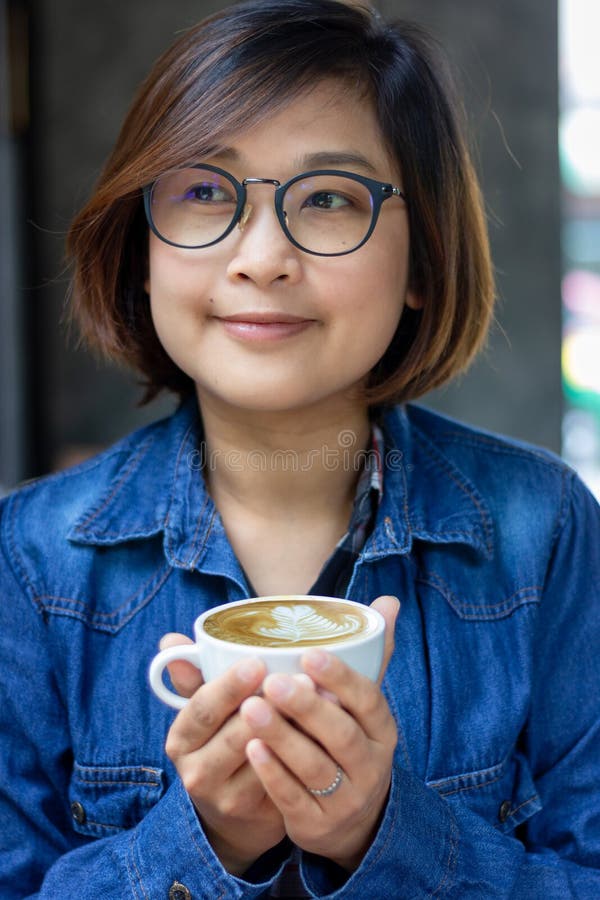 Chemise et main de port de blue-jean de femme tenant une tasse de caf? blanc plat image libre de droits Chemise et main de port de blue-jean de femme tenant une tasse de caf? blanc plat image libre de droits