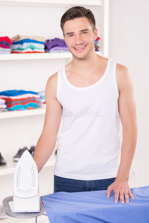 Chemise repassante d'homme avant de partir pour le travail photos stock
