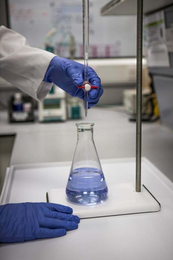 Chemist with Gloved Hands in a Laboratory Analysing a Sample by