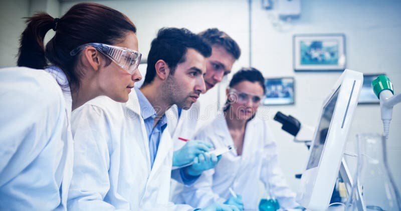 Chercheurs sérieux regardant l'écran d'ordinateur dans le laboratoire image stock