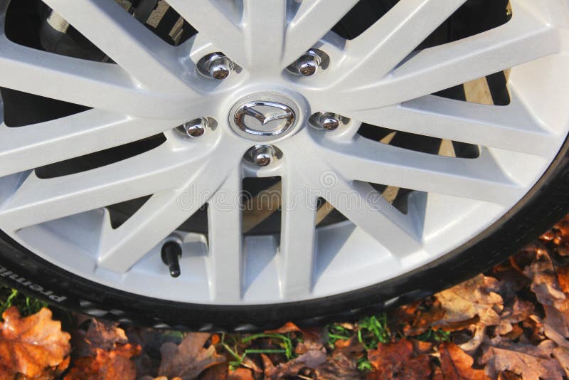 Mazda 6 MPS car wheel on the background of autumn leaves. Mazda 6 MPS car wheel on the background of autumn leaves
