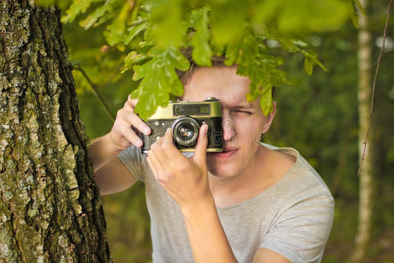 Chernihiv, Украина - 26-ое июля 2019: Парень в лесе фотографирует со старой камерой стоковое изображение rf