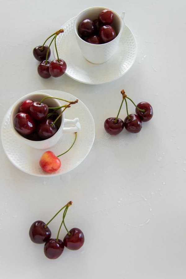 Cherries Season. Top View of Raw Cherries in White Cups Stock Photo