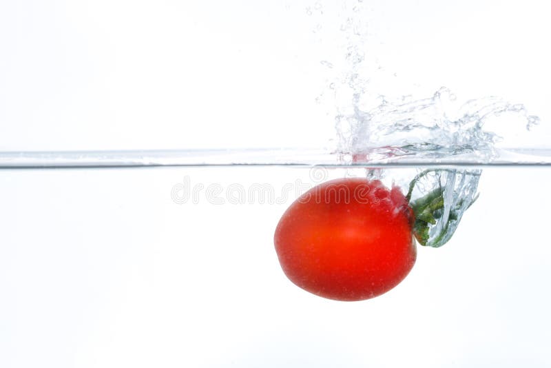 Cherry tomato falling into water with a splash