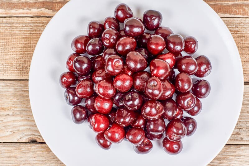 Cherries on white plate stock photo. Image of cheries - 120530992