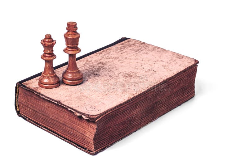 Chess pieces of a white king and Queen on an old battered book in retro style isolated on a white background