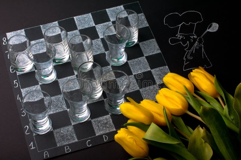 Focused man sipping alcoholic beverage while thinking about next chess move.  Stock Photo by DC_Studio