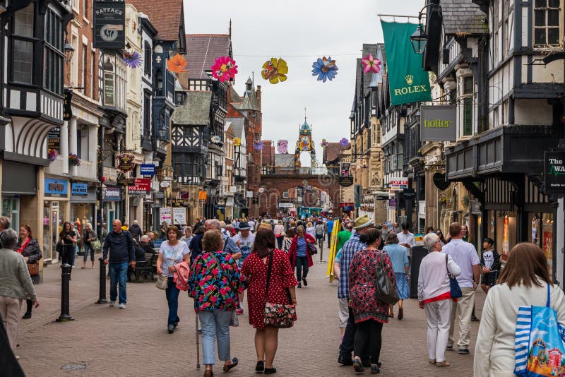 CHESTER UK - 26TH JUNI 2019: Ett skott ner den upptagna och berömda highstreeten i mitt av Chester, UK, Juni 2019 royaltyfri fotografi CHESTER UK - 26TH JUNI 2019: Ett skott ner den upptagna och berömda highstreeten i mitt av Chester, UK, Juni 2019 royaltyfri fotografi