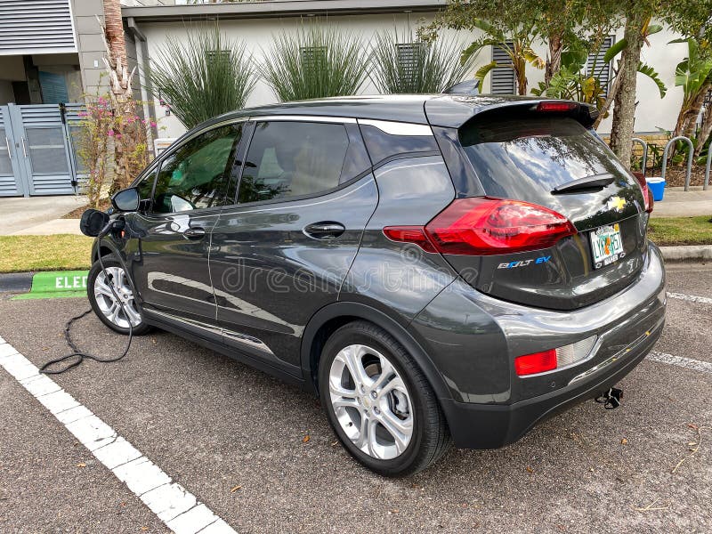 A Chevy Bolt electric vehicle charging at a free public charging station stock image A Chevy Bolt electric vehicle charging at a free public charging station stock image