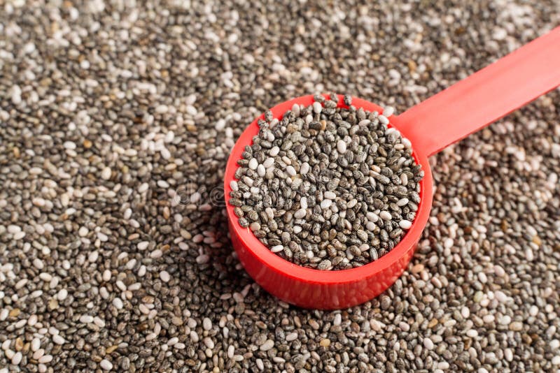 Chia seeds background. Chia seeds in a red measuring spoon stock images