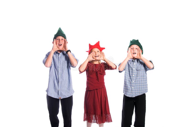 A group of children in elf hats with their hands cupped around their mouths calling Santa Claus. A group of children in elf hats with their hands cupped around their mouths calling Santa Claus