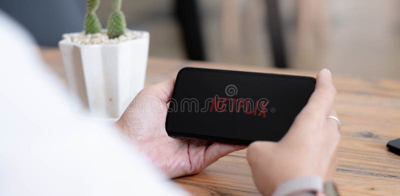 CHIANG MAI, THAILAND, AUG 2 2021 : Woman hand holding Smart Phone with Netflix logo on Apple iPhone Xs. Netflix is a global
