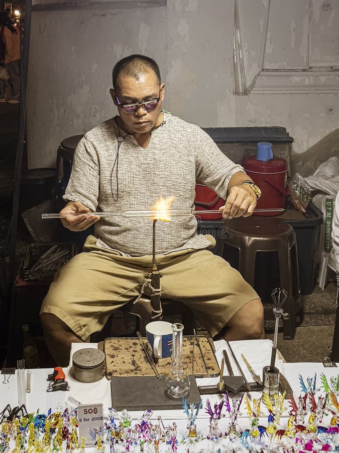 A glass blowing artist forms a blob of glass into a vessel using a gas torch  in Vermont Stock Photo - Alamy