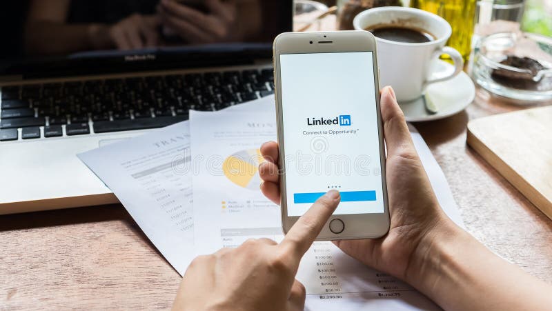 CHIANG MAI THAILAND MAY 09 2016: Affärskvinna som rymmer en iPhone 6 plus med service för socialt nätverk LinkedIn på skärmen iPh royaltyfria bilder CHIANG MAI THAILAND MAY 09 2016: Affärskvinna som rymmer en iPhone 6 plus med service för socialt nätverk LinkedIn på skärmen iPh royaltyfria bilder