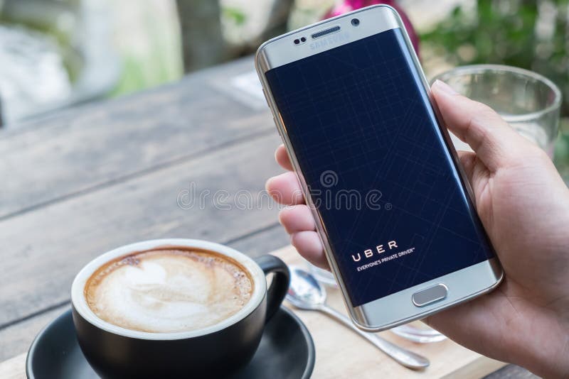 CHIANG MAI,THAILAND - NOV 20,2015 : A man hand holding Uber app welcome screen showing on Samsung galaxy s6 edge,Uber is smartphon royalty free stock photography
